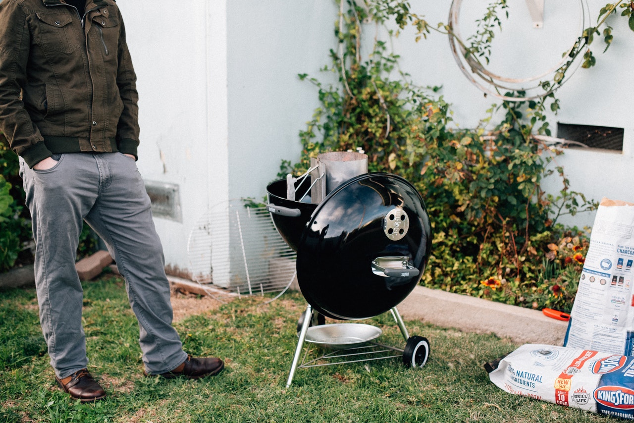 man next to barbecue grilling